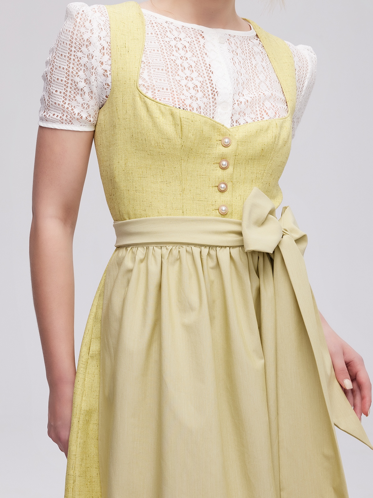 Ein elegantes gelbes Amuse Dirndl mit Spitzenbesatz